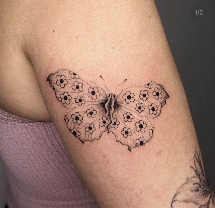 a woman's arm with a butterfly tattoo on the left side of her body