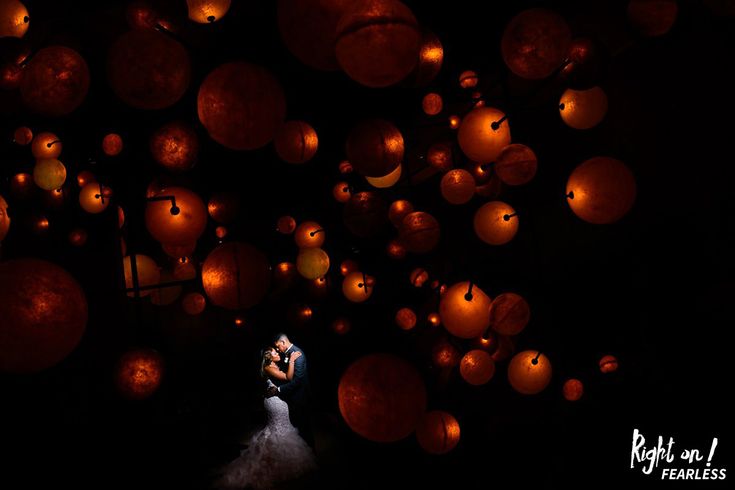 the bride and groom are surrounded by lanterns in the night sky at their wedding reception