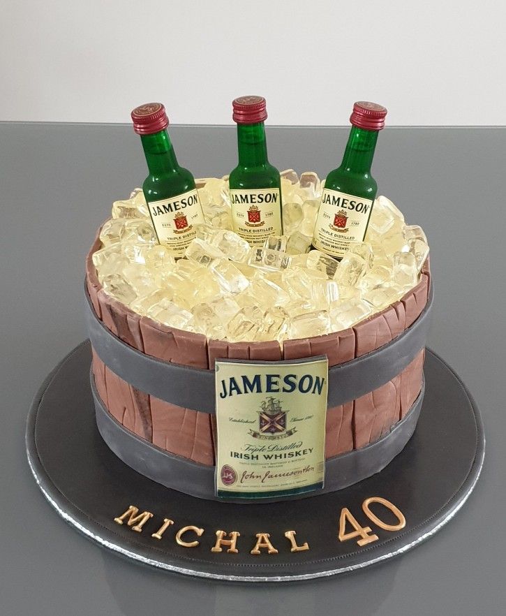 a cake made to look like a barrel with bottles of jameson in it and the number 40 on top