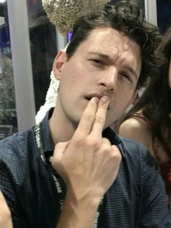 a man and woman posing for the camera with their fingers in their mouths as if they were kissing