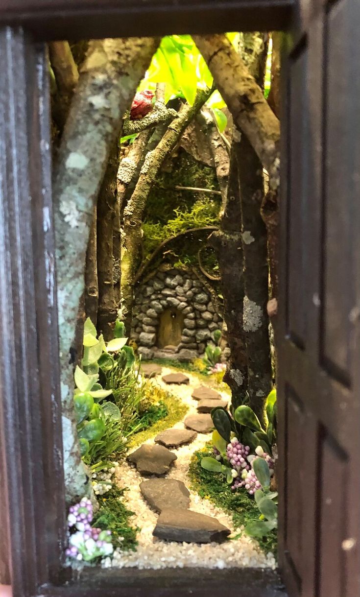 an open door to a small garden with rocks and plants