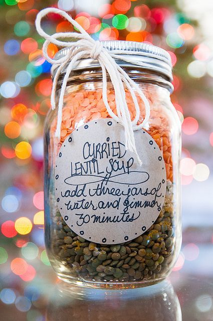 a jar filled with lots of different types of food next to a colorful christmas tree