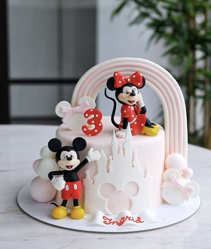 there is a cake with mickey and minnie on it