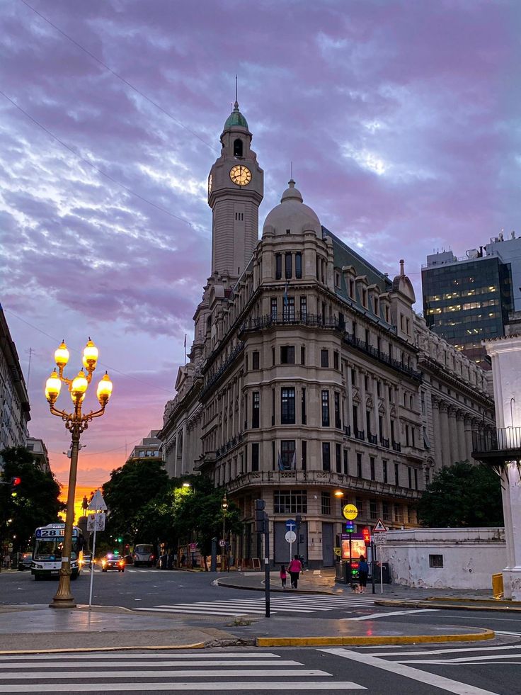 a large building with a clock tower in the middle of it's center surrounded by tall buildings