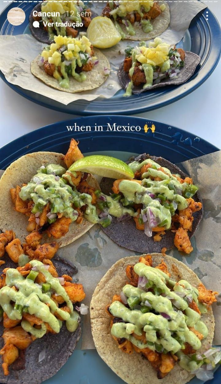 two plates filled with tacos covered in guacamole and other toppings