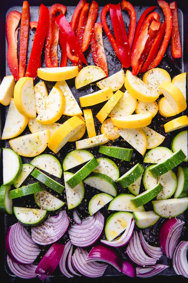 an assortment of vegetables cut up and ready to be cooked on a grilling sheet