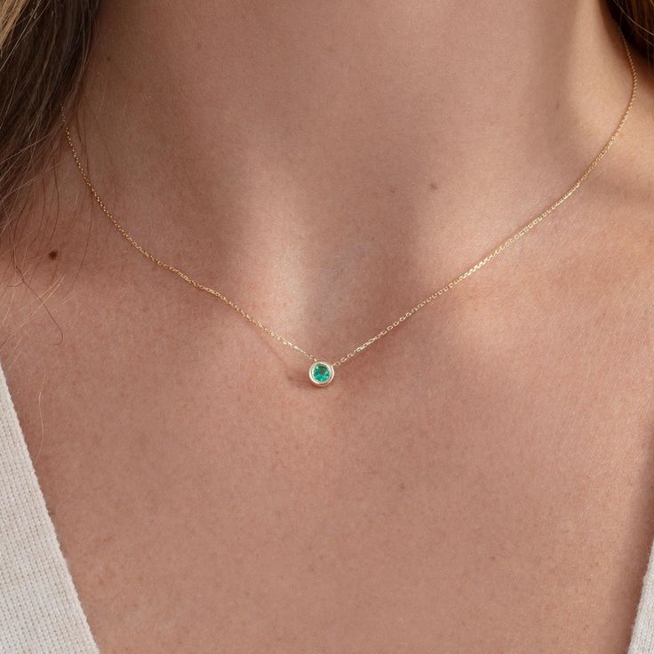 Embrace the captivating allure of this Solid Gold Emerald Bezel Necklace. This dainty pendant necklace features a vibrant, natural round emerald, expertly set in a sleek bezel setting of lustrous solid gold. The minimalist design highlights the emerald's rich green hue, symbolizing growth, renewal, and prosperity. - Handmade - Natural Emerald - Total Carat Weight Emerald: 0.11 ctw - Dimensions of Setting: 5.2 mm 🛠 Your Sarah Elise piece is handcrafted with care! Ready-to-ship items go out within 3 business days. Made-to-order pieces typically take 7-10 business days to create. If you need something sooner, please contact us - we'll see if we can make it happen! For estimated shipping dates and tracking, check your Etsy account under 'Orders'. 🚐Orders under $100 are sent with USPS First C Elegant Emerald Necklace With Round Pendant, Elegant Emerald Birthstone Necklace With Round Pendant, Elegant Emerald Round Pendant Necklace, Round Necklace With Bezel Setting, Fine Jewelry Round Birthstone Necklace, Solitaire Necklace With Round Cut Gemstone, Green Necklaces With Bezel Setting, Green Round Stone Necklace For May Birthstone, Green May Birthstone Necklace With Round Stone