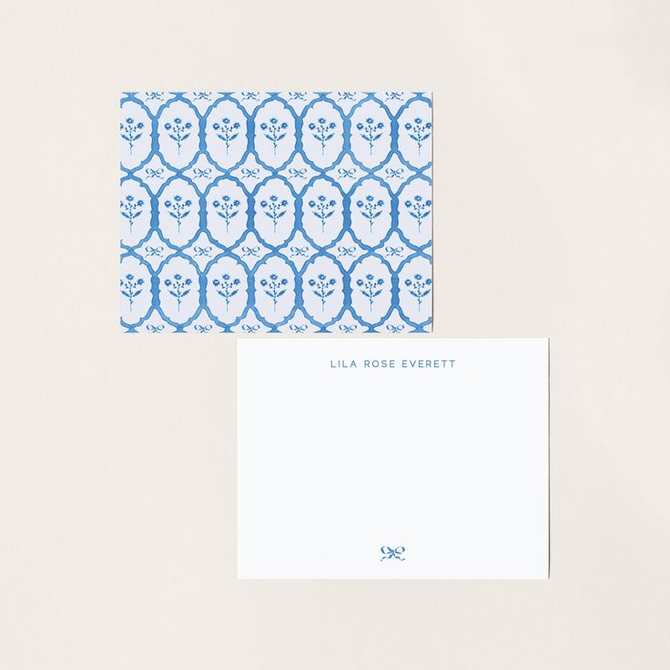 two blue and white envelopes sitting next to each other on top of a table