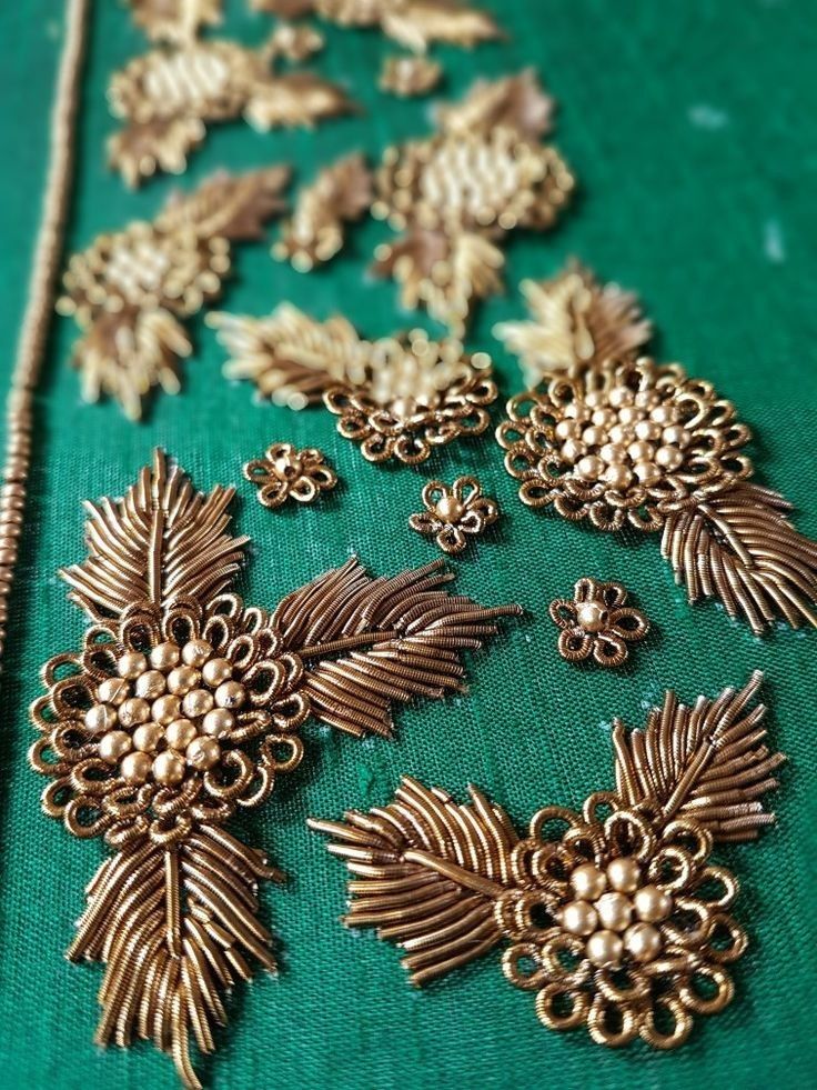 some very pretty gold brooches on a green cloth