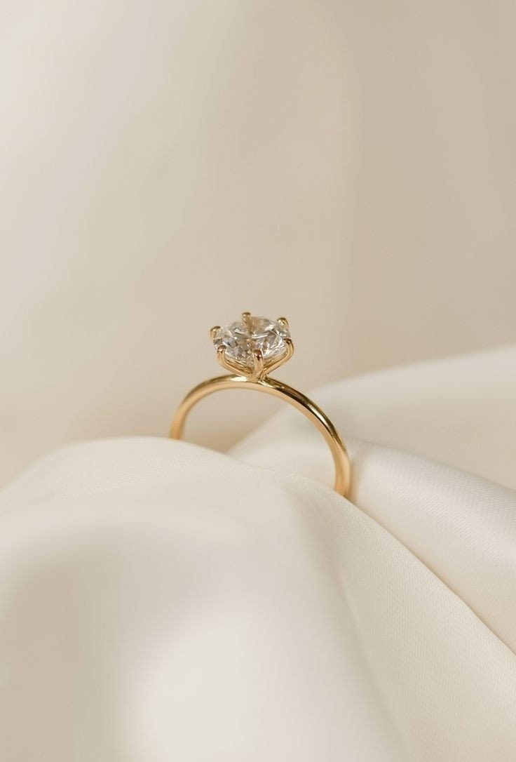 an engagement ring with two diamonds on it sitting on a white cloth in the sunlight