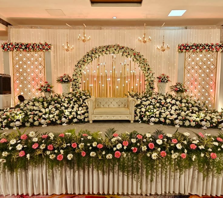 a wedding stage decorated with flowers and greenery