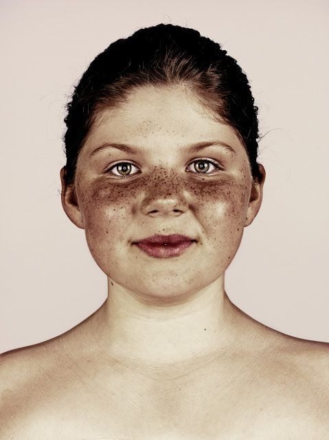 a woman with freckles on her face and one half of her body covered in dirt