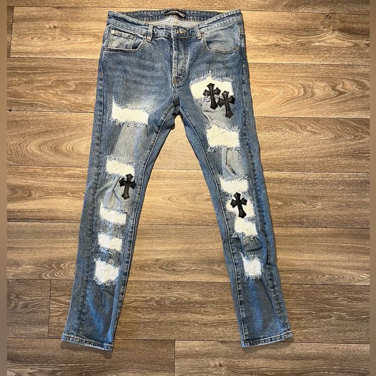 Elevate Your Wardrobe With These Rare Chrome Heart Denim Skinny Fit Jeans. The Distressed Detailing And Embroidered Accents On The Heart And Cross Theme Gives A Unique 90s Vibe To The Piece. These Pre-Owned Jeans Feature A Button Closure, Light Fabric Wash, And 30 In Inseam. Crafted From Quality Leather Material, These Blue Jeans Have A Waist Size Of 32 In And Fit True To Size. The Slim Fit And Pockets Are Perfect For A Modern And Stylish Look. These Jeans Are A Must-Have For Any Fashion-Forward Man. 1 Of 1 Chrome Hearts Jeans, Chrome Hearts Leather, Heart And Cross, Leather Cross, 1 Of 1, Chrome Hearts, Leather Material, Waist Size, Fit Jeans