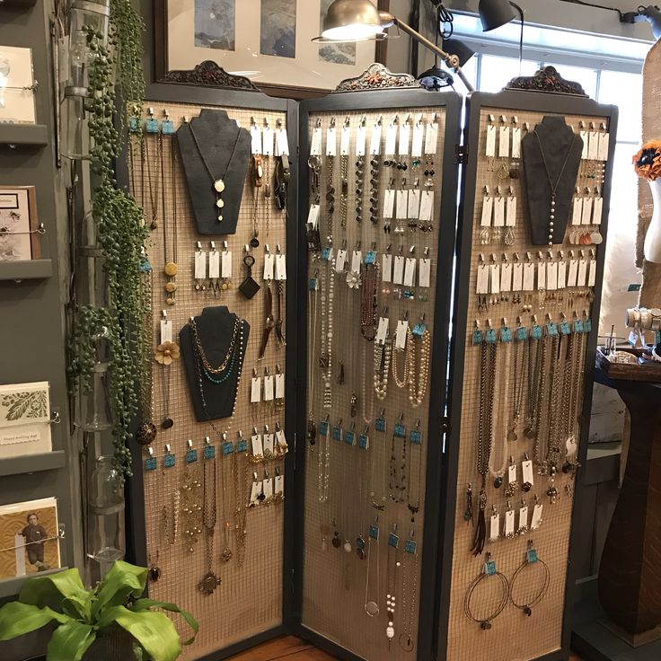 a display case filled with lots of necklaces and rings on it's sides