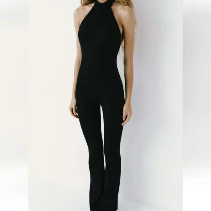 Full Length Jumpsuit Made Of Technical Fabric. Halter Neckline And Open Back. Button Closure At Neck And Hidden In Seam Zipper At Back Chic Stretch One-piece Jumpsuits And Rompers, Chic Stretch Jumpsuits And Rompers, Fitted Black Overall Jumpsuits And Rompers, Fitted Black Overall Jumpsuit, Black Fitted Overall Jumpsuit, Chic Fitted High Waist Jumpsuits And Rompers, Chic Fitted Overalls And Jumpsuits, Fitted Overall Pantsuit For Date Night, Fitted Black Summer Pantsuit