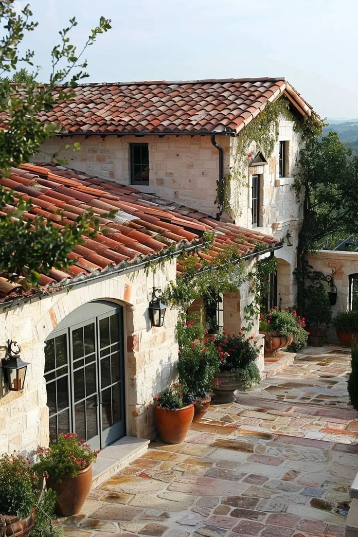 an outdoor patio with potted plants and stone buildings