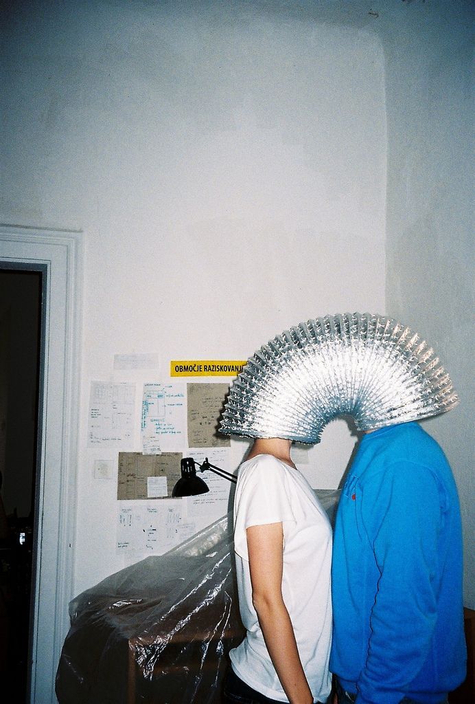 two people standing next to each other in a room with duct tape on their heads