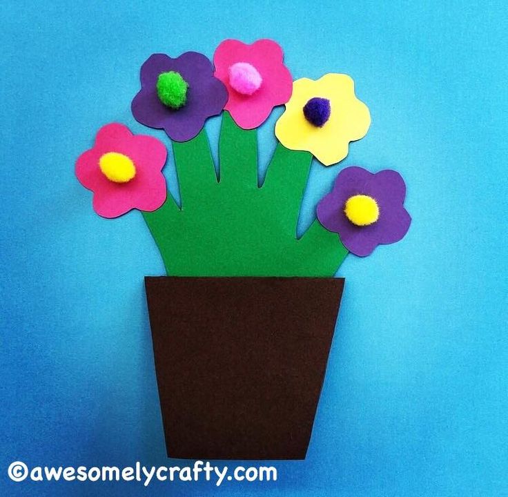 paper flowers in a brown vase on a blue background