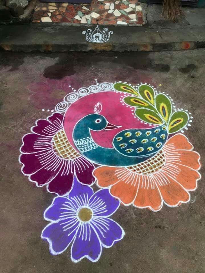 a colorful peacock on the ground next to flowers