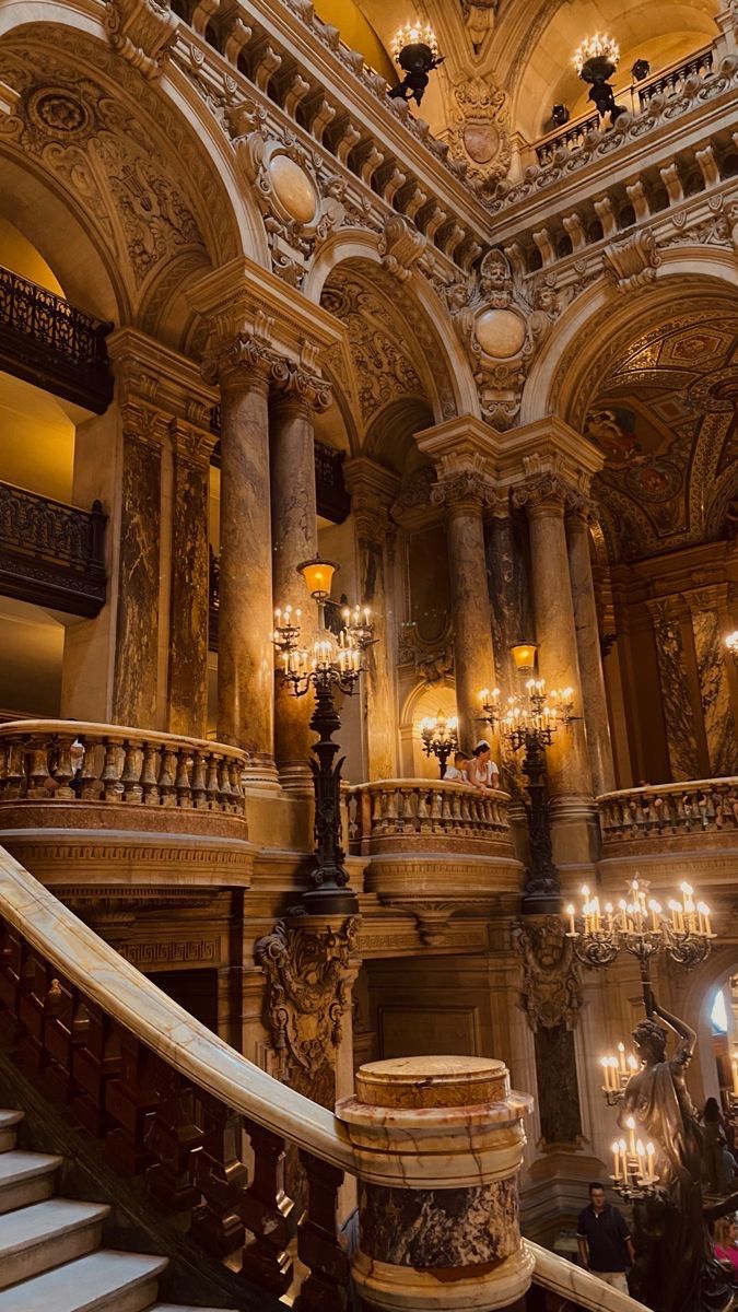 an ornate staircase with chandeliers in a building