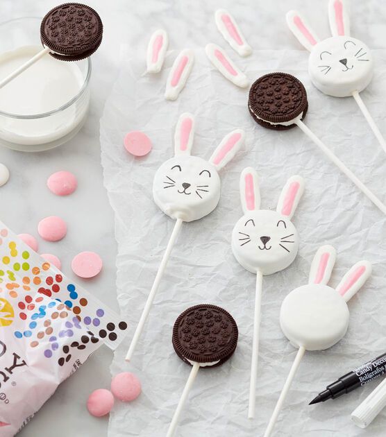 marshmallows, oreo cookies and bunny ears are arranged on a sheet of paper