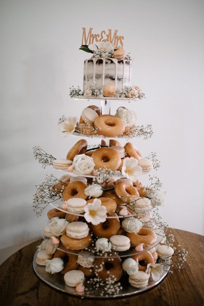 a tiered cake with donuts and other pastries sitting on top of it