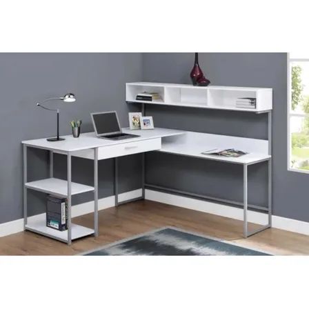 a computer desk with a laptop on top of it in front of a gray wall