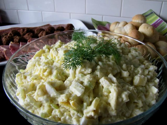 a bowl filled with potato salad next to other foods