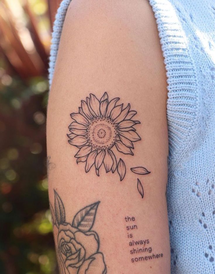 a woman's arm with a sunflower tattoo on the left side of her arm