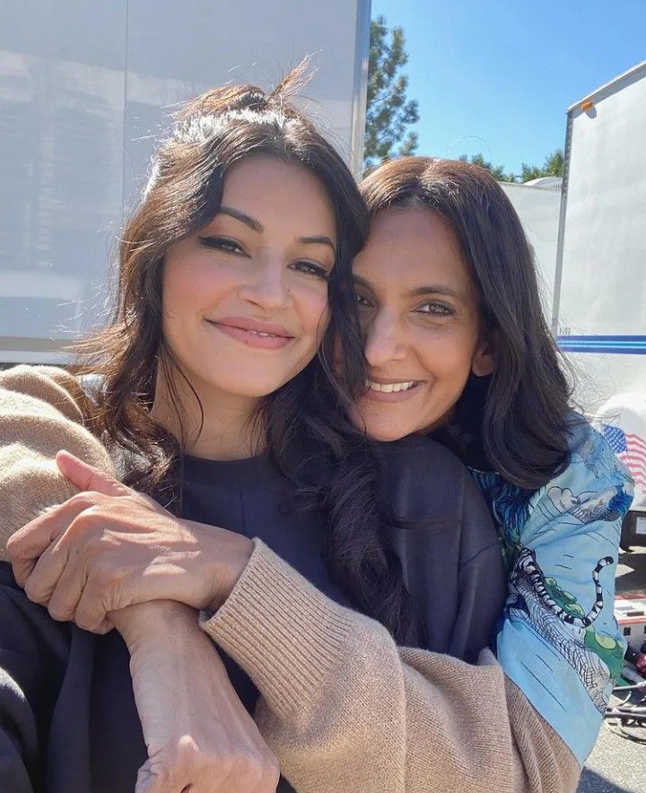 two women hugging each other in front of a trailer