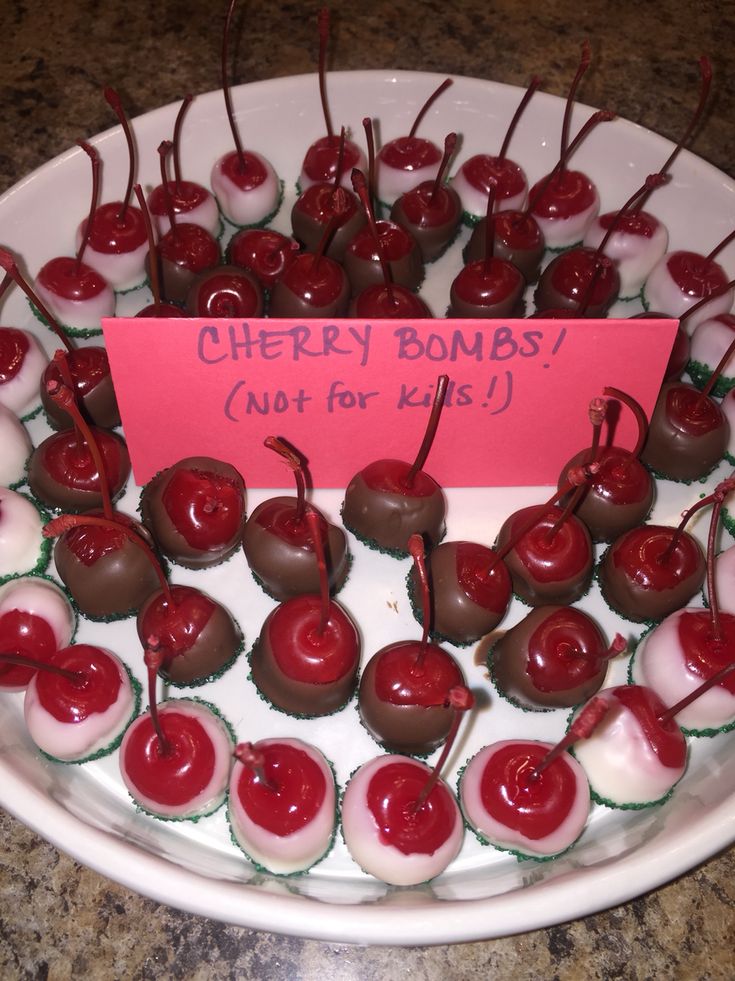 cherries are arranged in the shape of hearts on a platter with a sign