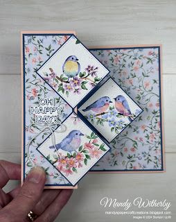 a hand holding up a card with two birds on it and the words happy birthday