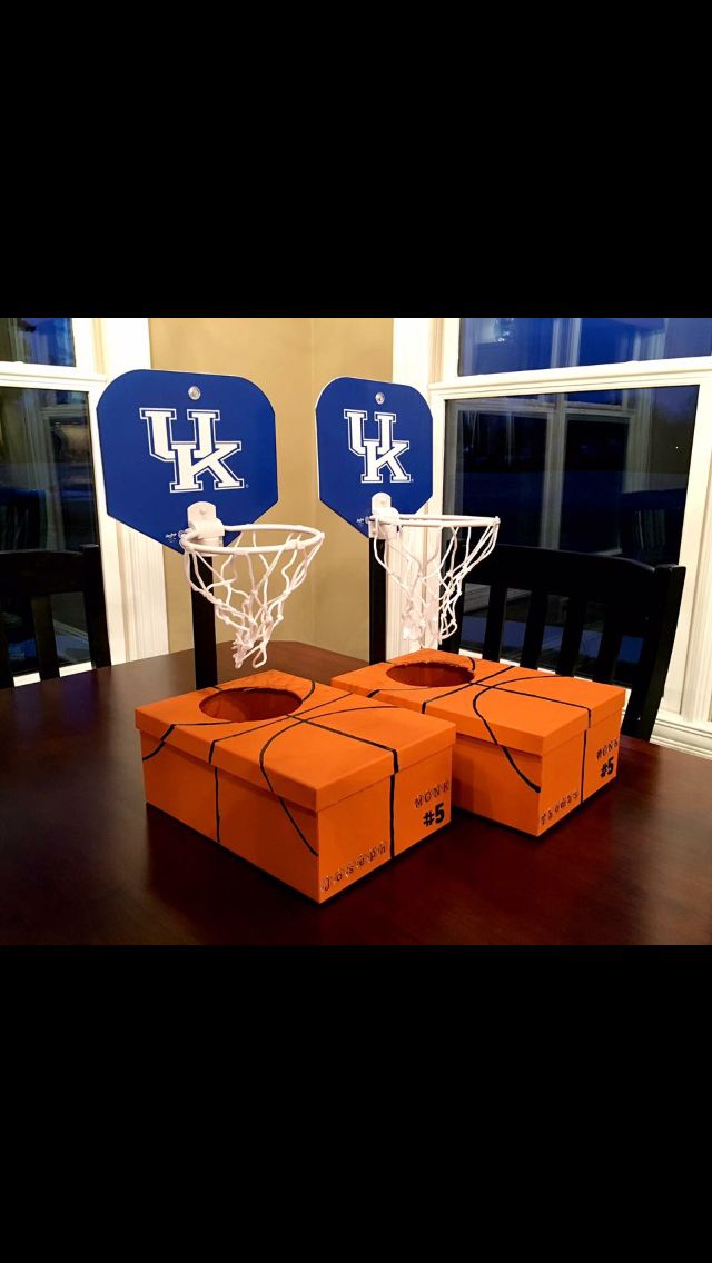 basketball hoop made out of orange boxes on a wooden table in front of a window