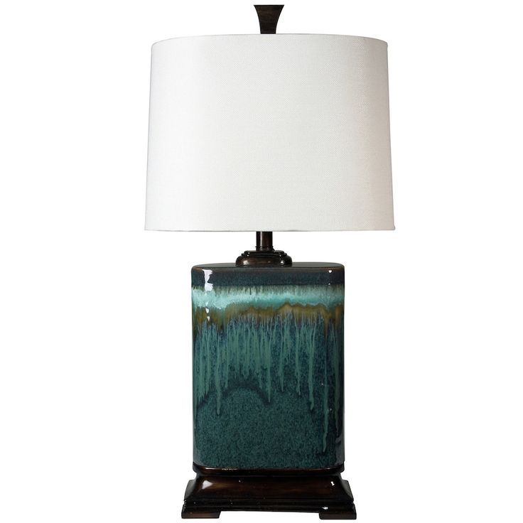 a table lamp with a white shade on it and a black base in front of a white background