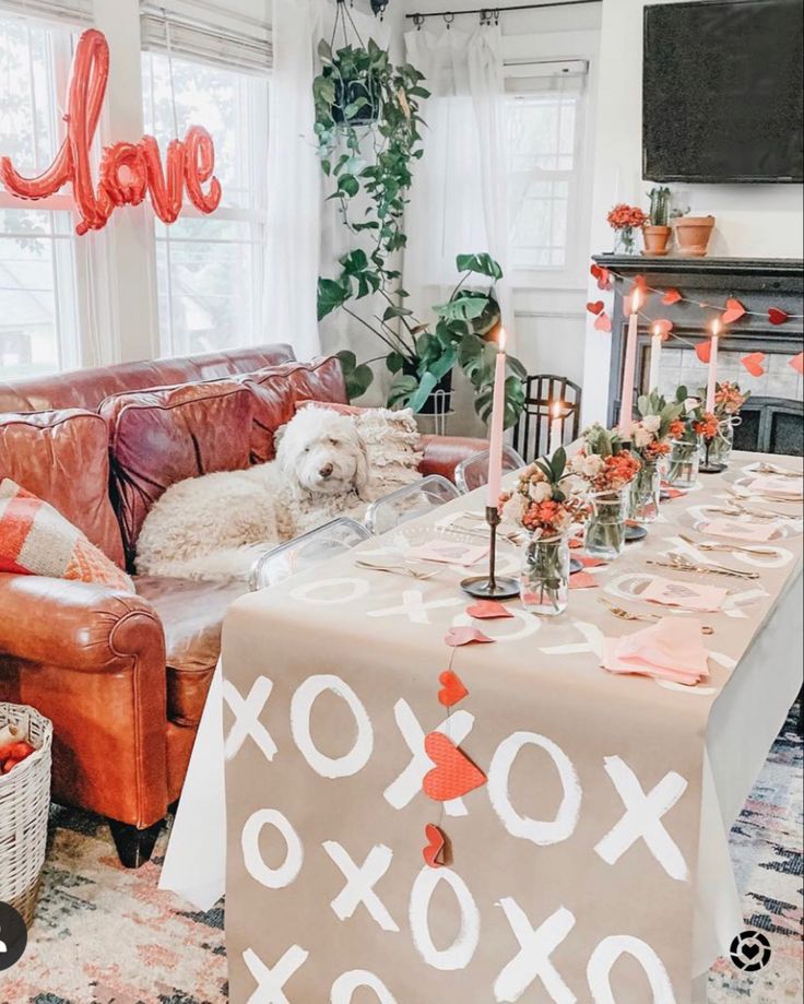 Table is in a living room with fun Valentine's Day decor all over Valentines Home Decor, Valentine Dinner Party, Galentines Day Ideas, Valentines Brunch, Valentines Party Decor, Galentines Party, Valentine Dinner, Heart Garland, My Funny Valentine