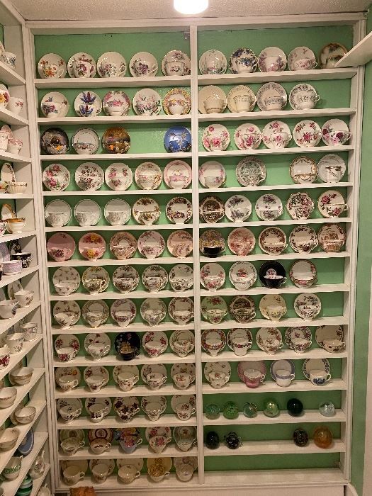 there are many plates on the shelves in this room