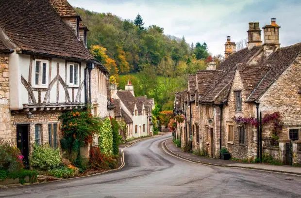 an empty street with houses on both sides and trees in the backgrouds