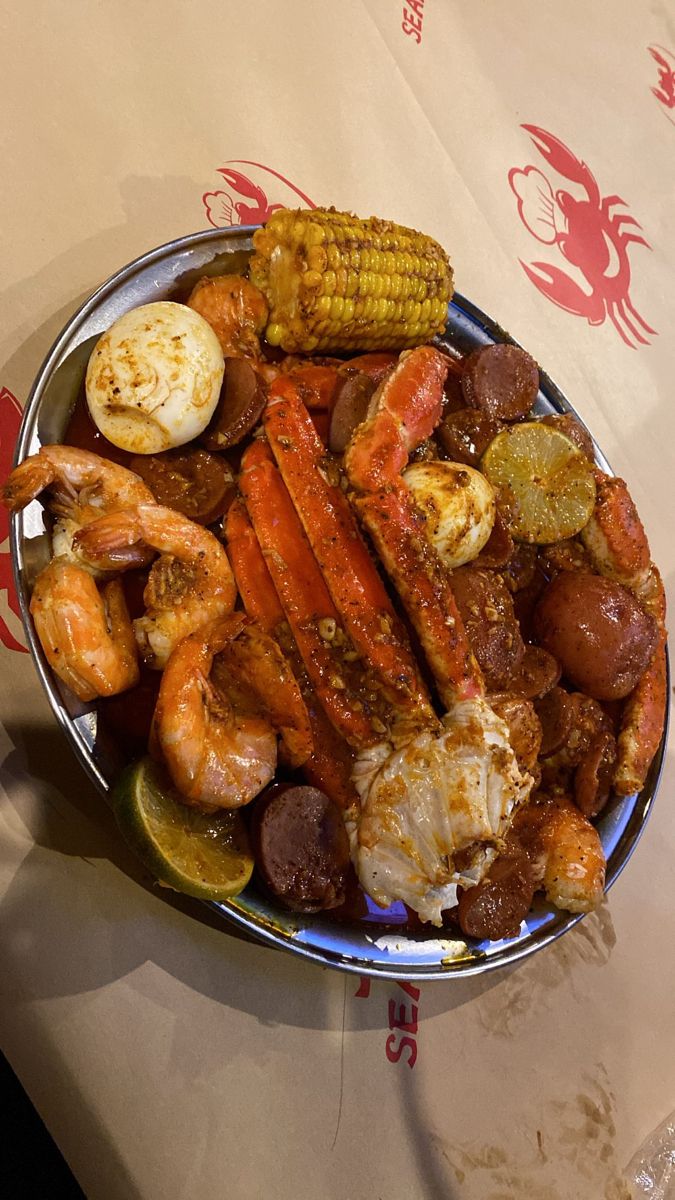 a plate full of seafood and corn on the cob