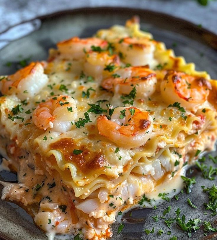 a close up of a plate of food with pasta and shrimp on it, garnished with parsley