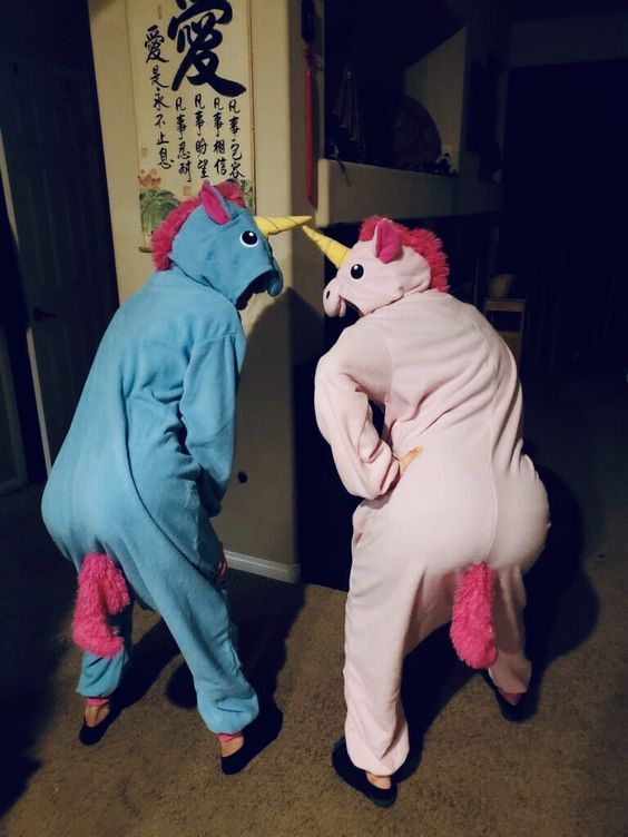 two people in costumes are standing next to each other and one is wearing a unicorn costume