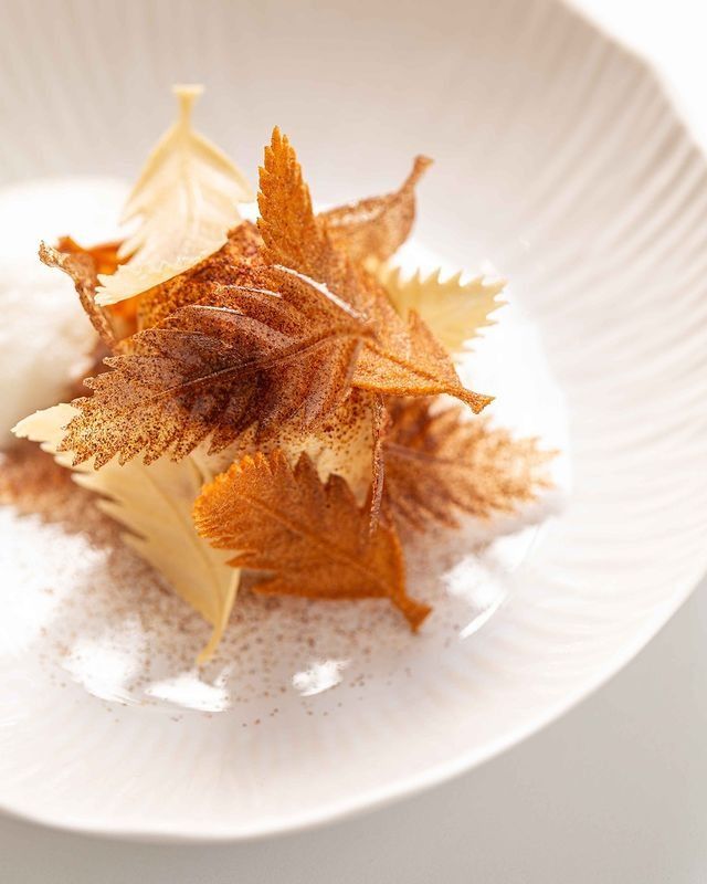 a white plate topped with leaf covered food