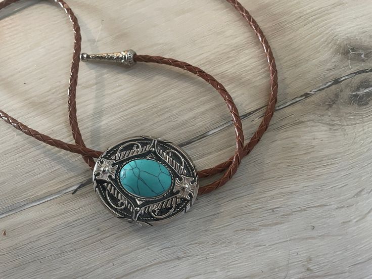 This awesome bolo tie has a southwestern design and agate centerpiece. The cord is genuine brown leather.Our bolos pair nicely with many of our belt buckles! They make wonderful gifts. The western bolo tie rope length is 39'' ; charm agate stone pendant size is 2'' x 1 1 /2'' Southwestern Bolo Tie With Sliding Knot, Bohemian Lariat Bolo Ties For Festivals, Southwestern Lariat Bolo Tie For Rodeo, Handmade Lariat Bolo Tie For Rodeo, Adjustable Concho Necklaces For Festival, Western Lariat Bolo Tie With Adjustable Length, Western Style Lariat Bolo Tie With Adjustable Length, Handmade Southwestern Bolo Ties, Handmade Southwestern Lariat Bolo Tie