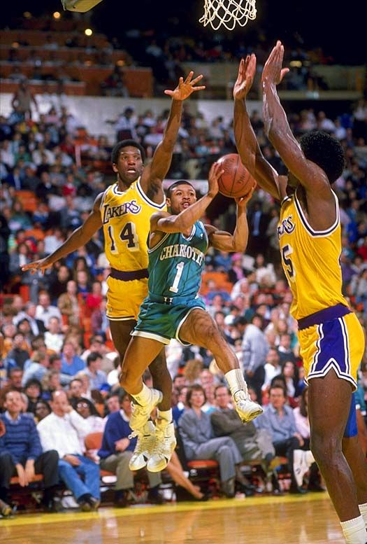 the basketball players are trying to block the ball from going into the basket during a game