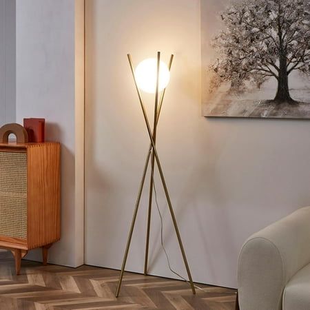 a living room scene with focus on the floor lamp and an art piece in the background