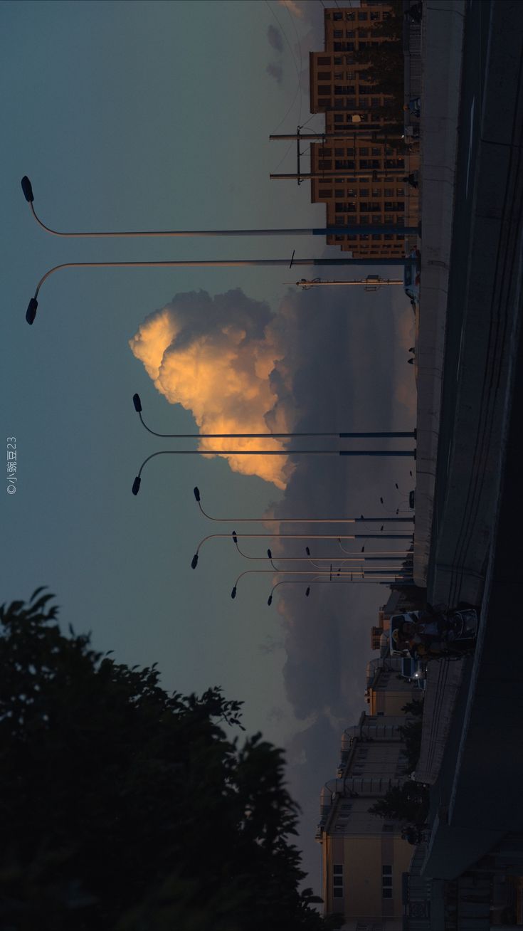 the sky is filled with clouds and some buildings