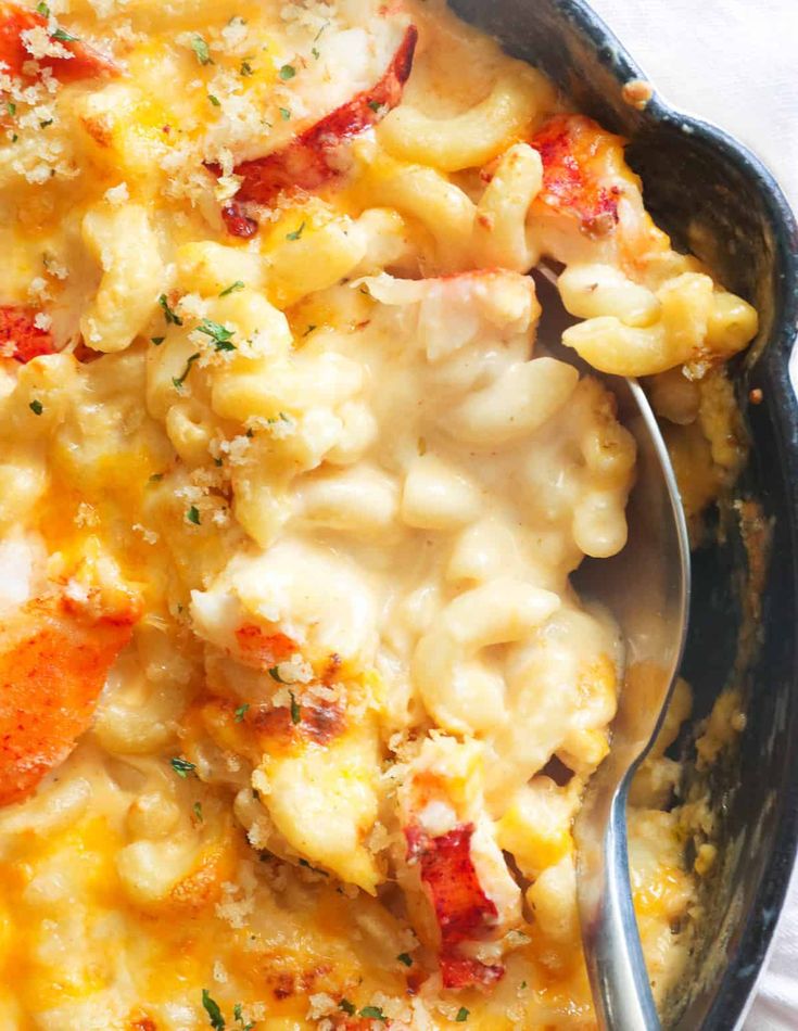 a bowl filled with macaroni and cheese on top of a white table cloth