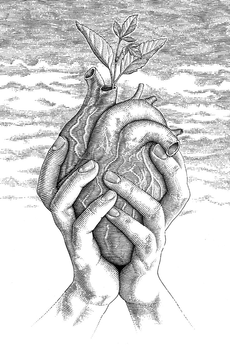 two hands holding a heart in front of the ocean