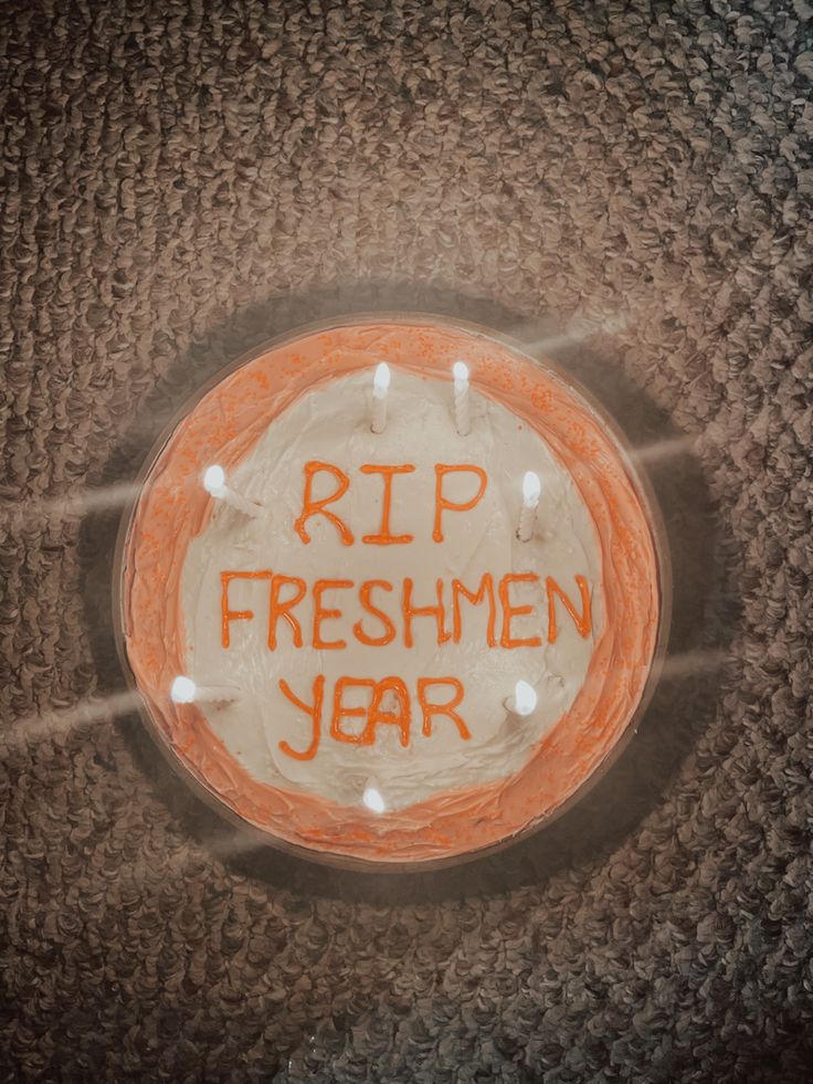 an orange and white cake with the words rip freshmen year written on it