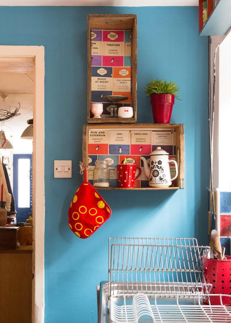 two wooden crates with cups and mugs on them hanging from the wall in a kitchen