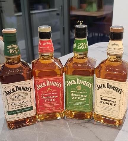 four bottles of jack daniels are lined up on a table